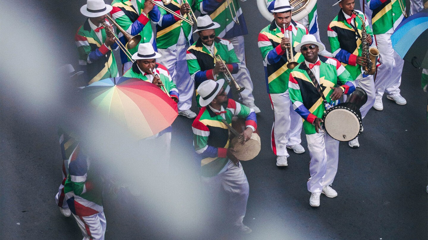 A group of street musicians in Cape Town, South Africa. They are wearing jackets with the colours of the South African flag.